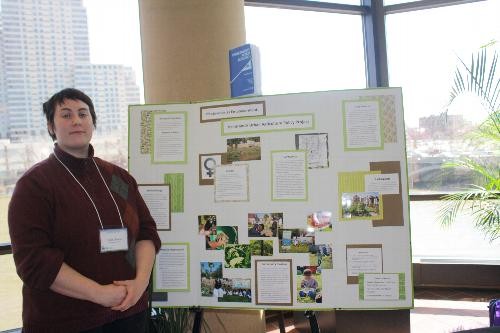 Student stands by poster presentation